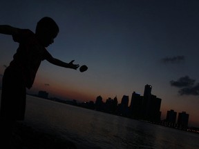 Kolt, 5, throws rocks into the Detroit River at dusk, Monday, July 22, 2013.  Many Windsorites were out enjoying the clear summer night sky along the Windsor's riverfront this evening.  (DAX MELMER/The Windsor Star)