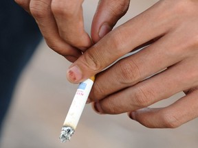 A woman smokes a cigarette. (Postmedia News files)