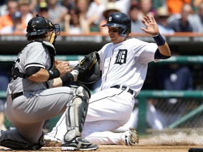 Detroit's Victor Martinez, right, is tagged out by Chicago catcher Josh Phegley on a throw from left fielder Dayan Viciedo during the fourth inning in Detroit, Thursday, July 11, 2013. (AP Photo/Carlos Osorio)