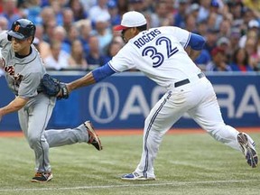 Toronto's Esmil Rogers, right, tags Detroit's Andy Dirks in a rundown in the third inning on July 4, 2013 at Rogers Centre in Toronto, Ontario, Canada. (Photo by Tom Szczerbowski/Getty Images)