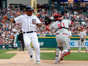 Detroit's Ramon Santiago, left, scores as  Philadelphia catcher Carlos Ruiz is pulled off the plate on a bad throw in the sixth inning at Comerica Park July 28, 2013 in Detroit. (Gregory Shamus/Getty Images)
