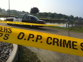 Investigators with the Ontario Provincial Police tape off a section of Towle Harbour on Bevel Line Road in Leamington Wednesday, July 10, 2013. (Twitpic: Trevor Wilhelm/The Windsor Star)