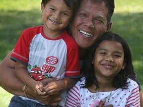 Antoni Tambunan is shown Tuesday, July 30, 2013, with his niece Carmen and nephew Christian at their Tecumseh, Ont. home. They will soon travel to Indonesia for a memorial event for family members who were killed during the 2004 Boxing day tsunami. (DAN JANISSE/The Windsor Star)