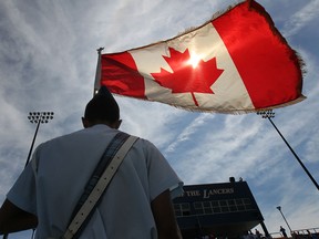 A member of the honour guard holds a Canadian flag Saturday, August 17, 2013, at the International Children's Games in Windsor.  (DAN JANISSE/The Windsor Star)