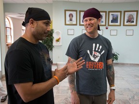 Pardeep Kaleka, left, and Arno Michaelis talk at the Sikh Temple of Wisconsin in Oak Creek, Wis., July 31, 2013. A year ago a white supremacist shot and killed six temple members, including Kaleka's father. Michaelis, a former skinhead, reached out to Kaleka after the shooting and since then the pair have formed an unlikely alliance. (AP Photo/Morry Gash)