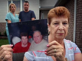 Beverley Turner holds a photograph of herself and her husband William Turner on  August 12, 2013. Her husband suffers from Alzheimer's and resides at Huron Lodge nursing home. Daughter Tereasa Nixon, and her husband Lee Nixon, at back, and family members are hoping his caregivers respect William's living will.  (NICK BRANCACCIO-The Windsor Star)