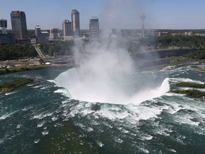 The town of Niagara Falls, Ont., is seen past a cloud of mist rising over Horseshoe Falls, N.Y. on June 4, 2013. (John Moore/Getty Images)