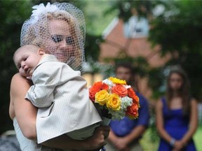 Christine Swidorsky carries her son and the couple's best man, Logan Stevenson, 2, down the aisle to her husband-to-be Sean Stevenson during the wedding ceremony on Saturday, Aug. 3, 2013 in Jeannette, Pa. The Stevensons abandoned an original wedding date of July 2014 after learning from doctors late last month that their son had two to three weeks to live, suffering from leukemia and other complications. The couple wanted Logan to see them marry and to be part of family photos. (Eric Schmadel, AP Photo/Tribune Review)