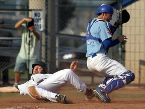 The Brandon Cloverleafs Derek Chapman slides safely into home and around the Fredericton Royals catcher Jody Peterson at Cullen Field during the Canadian Senior Baseball Championships in Windsor on Thursday, August 22, 2013.         (TYLER BROWNBRIDGE/The Windsor Star)