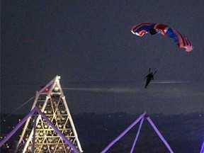 In this July 27, 2012 file photo, British stuntman Mark Sutton, parachuting into the Olympic Stadium, dressed as James Bond, during the Olympic Games 2012 Opening Ceremony in London. The British stuntman has been killed in an accident in the Swiss Alps while flying a special wing suit. Online extreme sports broadcaster Epic TV says Sutton died during a gathering it had organized involving 20 wing suit pilots who were being filmed as they jumped from helicopters. Swiss police confirmed that a 42-year-old Briton died Wednesday, Aug. 14, 2013, in a fall near Trient in the Valais region. (AP Photo/PA, Lewis Whyld, File)