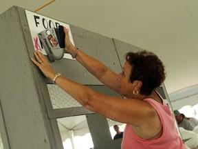 Joyce Poynter hangs up signs as crews set up for the Tecumseh Cornfest on Tuesday, August 21, 2013.         (TYLER BROWNBRIDGE/The Windsor Star)