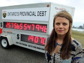 In this file photo, Candice Malcolm is photographed next to the Canadian Taxpayers Federation's debt clock along the riverfront in Windsor, Ont. on Tuesday, August 27, 2013. (TYLER BROWNBRIDGE/The Windsor Star)
