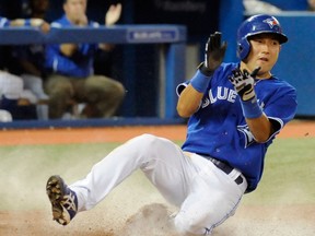 Toronto's Munenori Kawasaki celebrates as he slides into home to tie the game against the Kansas City Royals during the eighth inning Saturday. (THE CANADIAN PRESS/Jon Blacker)