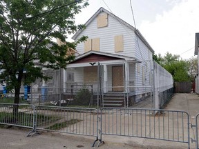 A 10-foot chain link fence surrounds the home of Ariel Castro in Cleveland in this May 14, 2013 file photo. The house where three women were held captive and raped over a decade in Cleveland was demolished  Wednesday Aug. 7, 2013. The house was demolished as part of a deal that spared Castro a possible death sentence. He was sentenced last week to life in prison plus 1,000 years. (AP Photo/Mark Duncan, File)