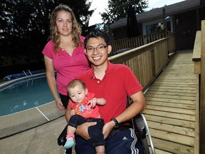 Kystal and Auh Tuan Nguyen are photographed with their daughter Vivian at the base of a ramp at the back of their family home in Windsor, Ont. on Thursday, August 15, 2013. Auh Tuan was paralyzed when he fell while trimming the tree in the front of their home. Friends and family are hosting a benefit to raise money for the couple.             (TYLER BROWNBRIDGE/The Windsor Star)