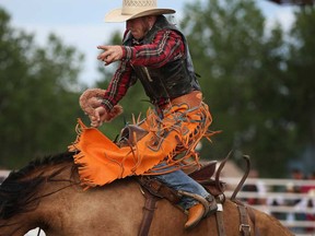 A cowboy competes in the saddle bronc riding competition at the 2013 Sun Parlour Rodeo at Easy Walking Stables in Kingsville, Sunday, August 4, 2013. (DAX MELMER/The Windsor Star)