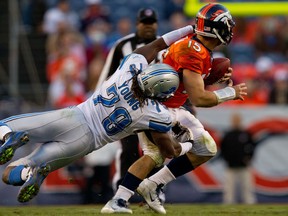 Lions defensive end Willie Young, left, tackles Denver quarterback Tim Tebow at Mile High Stadium in 2011. (Photo by Justin Edmonds/Getty Images)