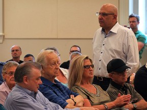 Harvey Strosberg, standing talks with west end residents at a meeting about the lawsuit against the Canadian Transit Company, who own the Ambassador Bridge on August 27, 2013.  CTC president Dan Stamper, at left, sits with the residents. (NICK BRANCACCIO/The Windsor Star)