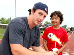 LaSalle's Luke WIllson signs an autograph for Darrius Gerard at Raider Field in Essex. (REBECCA WRIGHT/The Windsor Star)