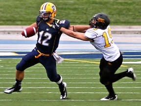 Guelph's Bryan Dunjko, right, grabs a hold of Windsor quarterback, Austin Kennedy at Alumni Field last year. (REBECCA WRIGHT/The Windsor Star)