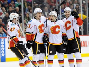 Calgary's Sven Baertschi, from left, Mikael Backlund, ex-Spit Mark Cundari and former Leamington defenceman T.J. Brodie celebrate Cundari's first NHL goal against the Minnesota Wild. (Photo by Hannah Foslien/Getty Images)