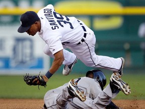 Tigers second baseman Ramon Santiago, top, jumps over Chicago's Alejandro De Aza as De Aza steals second during the third inning Saturday in Detroit. (AP Photo/Carlos Osorio)
