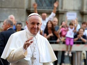 In this file photo, Pope Francis salutes as he arrives at the Chiesa Del Gesu' in Rome on July 31, 2013. The Pontiff has charmed the masses with his informal style, simplicity and sense of humour — and a handful of strangers have gotten the treatment up close, receiving papal phone calls out of the blue after writing him or suffering some personal tragedy. (Alberto Pizzoli/AFP/Getty Images)