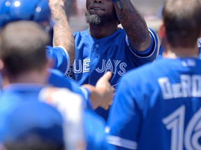 Toronto's Jose Reyes is congratulated after scoring on a single by Rajai Davis during the third inning against the Los Angeles Angels Sunday. (AP Photo/Mark J. Terrill)