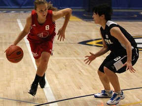 Olivia Starling, left, from Windsor-Essex, drives past South Korea's Kim Min Jung, during the girls basketball gold-medal game in the International Children's Games at the St. Denis Centre, Sunday, August 18, 2013.  (DAX MELMER/The Windsor Star)