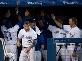 Blue Jays centre fielder Rajai Davis, left, celebrates with teammates in the dugout after scoring a run against the Boston Red Sox during third inning in Toronto on Wednesday, August 14, 2013. THE CANADIAN PRESS/Nathan Denette