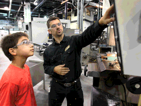 Technician Gary Anger, right, shows Benjamin St. Amour, 12, a CNC machine during a skilled trades camp at St. Clair College on Aug. 15, 2013. (DAN JANISSE/The Windsor Star)