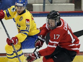 Canada's Connor McDavid, right, handles the puck in front of Sweden's Gustav Possler during their junior evaluation camp exhibition game on August 8, 2013 in Lake Placid, New York.  (Photo by Bruce Bennett/Getty Images)