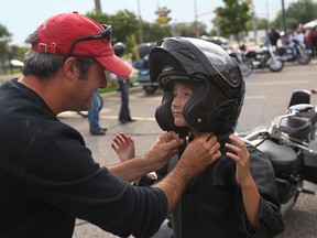 Paul Chenier, left, helps his daughter, Emma, 11, with her helmet before embarking on the 8th annual Ride for the Breath of LIfe Motorcycle Ride from Applebees restaurant, Sunday, Sept. 4, 2011.  (DAX MELMER / The Windsor Star)
