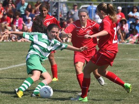 Ireland's Elizabeth Mohan, left, gets pressured by Windsor-Essex's Kyla Sovran and Julia Albeartie during their game Friday, Aug. 16, 2013, at the International Children's Games in Windsor, Ont. (DAN JANISSE/The Windsor Star)