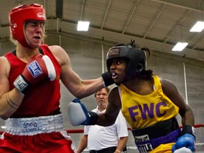 Olympic gold medallist Claressa Shields, right, fights Alison Greey of the Windsor Amateur Boxing Club at Kettering University Thursday, Aug. 8, 2013. Williams won in a four-round unanimous decision. (AP Photo/The Flint Journal,Zack Wittman)