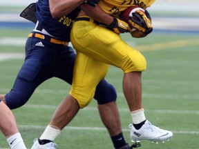 Lancers running back Mitch Dender, right, is tackled by defensive back Dave McDuffie during training camp Thursday at Alumni Field. (NICK BRANCACCIO/The Windsor Star)