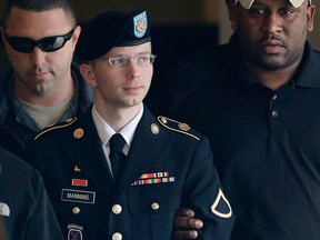 In this Tuesday, Aug. 20, 2013 file photo, Army Pfc. Bradley Manning is escorted to a security vehicle outside a courthouse in Fort Meade, Md., after a hearing in his court martial. On Wednesday, Aug. 21, 2013, Manning was sentenced to 35 years in prison for leaking a trove of classified information to the anti-secrecy website WikiLeaks. (AP Photo/Patrick Semansky, File)