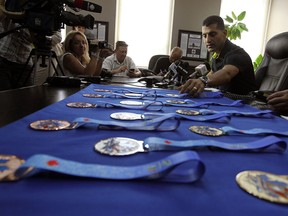 The medals for the upcoming children's games are unveiled by Mayor Eddie Francis at city hall in Windsor on Friday, August 9, 2013.            (TYLER BROWNBRIDGE/The Windsor Star)