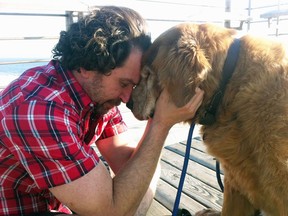 Charlie Annenberg, left, nuzzles his golden retriever, Lucky, at the Pipeline Beach in Ehukai Beach Park, Haleiwa, Hawaii.  For 16 years, Lucky has been his sidekick, soul mate and inspiration, said Annenberg.  (AP Photo/Explore.org)