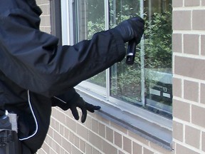 A police officer examines a break-and-enter scene for evidence in this 2012 file photo. (Dan Janisse / The Windsor Star)