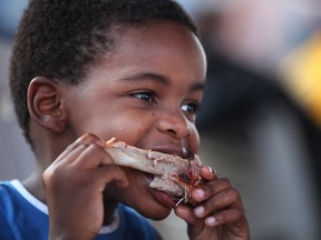 Josh Dos Santos, 4, from Toronto digs into some ribs at Windsor Ribfest at the Riverfront Festival Plaza, Saturday, August 24, 2013.  (DAX MELMER/The Windsor Star)