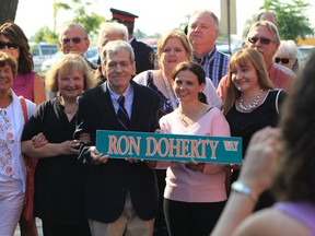 Ron Doherty is all smiles as he poses for a photo with family and dignitaries during a ceremony on Riverside Drive east.  Ron Doherty Way was officially unveiled. (JASON KRYK/The Windsor Star)
