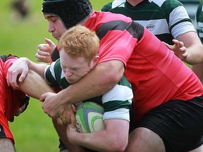 Windsor' Rogue's Jeremy Revenburg, right, battles a Highland RFC player during Niagara Rugby Union action at AKO Park, Saturday, August 10, 2013. The Windsor Rogues won 13-10. (DAX MELMER/The Windsor Star)