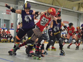 Border City blocker Diane Vassallo, left, battles against 
the Killer Queens in recent flat-track roller derby action. (Photo coutesy of Sanja Frkovic)