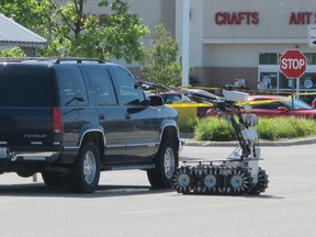 The robot of the Windsor police explosive disposal unit examines a Chevy Tahoe in the parking lot of the Real Canadian Superstore on Walker Road on Aug. 23, 2013. (Dalson Chen / The Windsor Star)