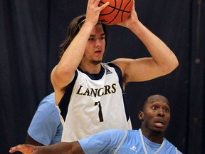 Lancers forward Evan Matthews, left, makes a play over Southern University's Christopher Hyder during the OUA/NCAA Tip-Off Classic at the St. Denis Centre August 14, 2013. (NICK BRANCACCIO-The Windsor Star)