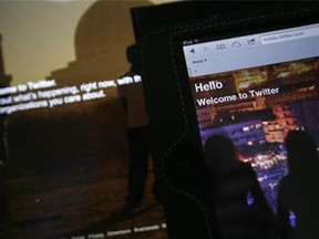 The home page for Twitter is displayed on an iPad and a laptop computer on July 31, 2013. (Alastair Grant/The Associated Press)