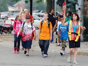 Last September's General Brock students Kyleigh Mallen, 10, left, Zack Freeswick, 11, Kale Mallen,11, Curtis Mathis, 8, get help to cross the street from crossing guard Joanne Westfall on September 4, 2012. (NICK BRANCACCIO/The Windsor Star)