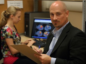 Dr. Chris Abeare, University of Windsor department of psychology, right, and student Ashley Seguin in a temporary laboratory September 5, 2013.  Dr. Abeare has initiated a sports concussion clinic.  (NICK BRANCACCIO/The Windsor Star)