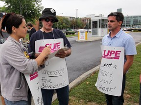 CUPE Local 1393 members Daria Milenkovic, left, Lionel Beaudion and David Court on the University Avenue picket line following a contract dispute with University of Windsor, Monday September 09, 2013. Striking members were asked to sign in while participating in strike duties. (NICK BRANCACCIO/The Windsor Star)